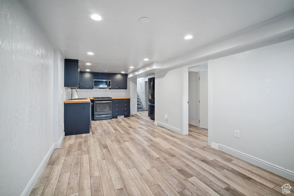 Unfurnished living room with light wood-type flooring, recessed lighting, and baseboards