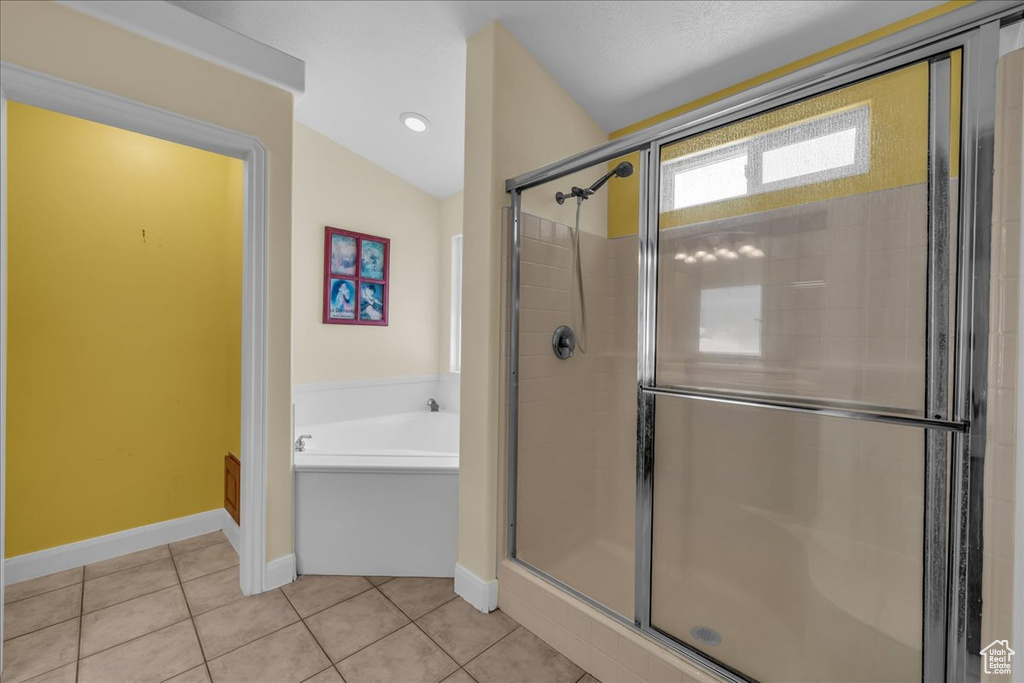 Bathroom with a garden tub, a shower stall, and tile patterned floors