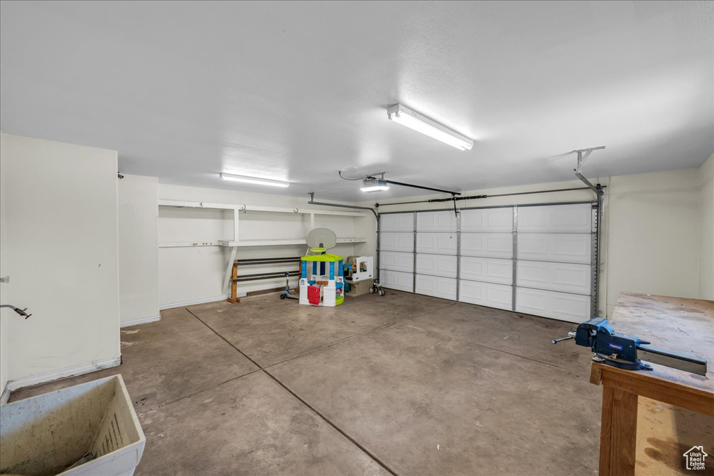 Garage featuring a garage door opener and baseboards
