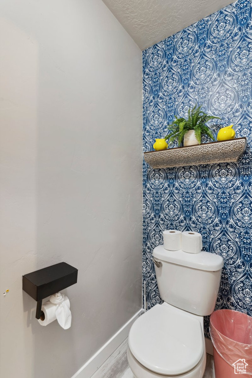 Bathroom featuring toilet and a textured ceiling