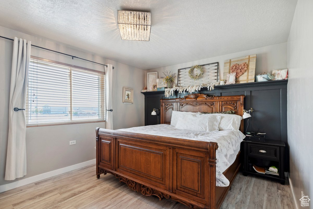 Bedroom with light wood-style flooring and a textured ceiling