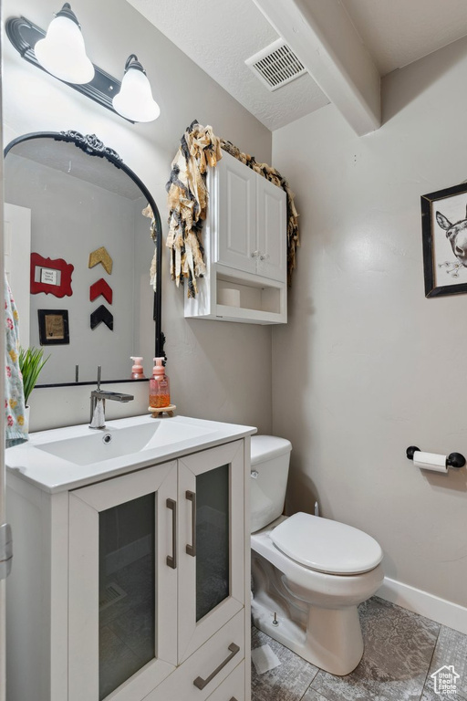 Half bathroom featuring toilet and vanity