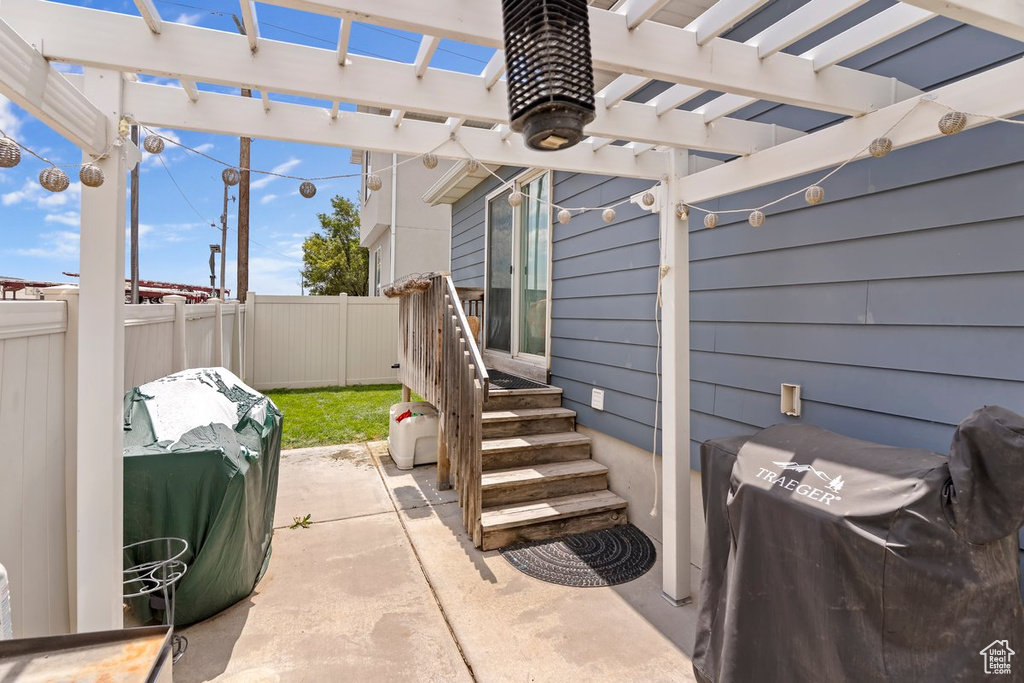 Fenced backyard with area for grilling, a pergola, and a patio