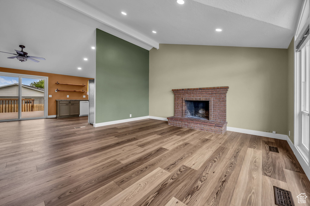 Unfurnished living room featuring a brick fireplace, ceiling fan, wood finished floors, and recessed lighting