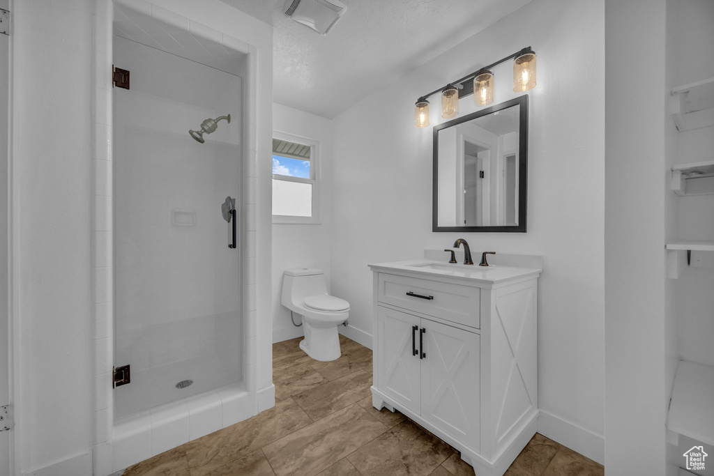 Bathroom featuring tiled shower and vanity