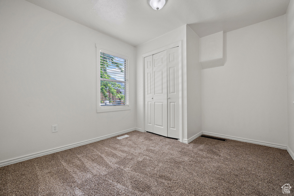 Unfurnished bedroom featuring carpet and a closet