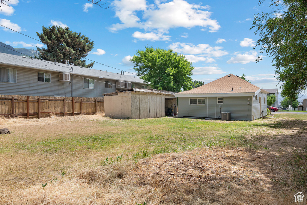 View of yard with a storage unit and an AC wall unit