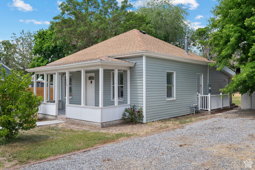 View of front of property featuring covered porch and a shingled roof