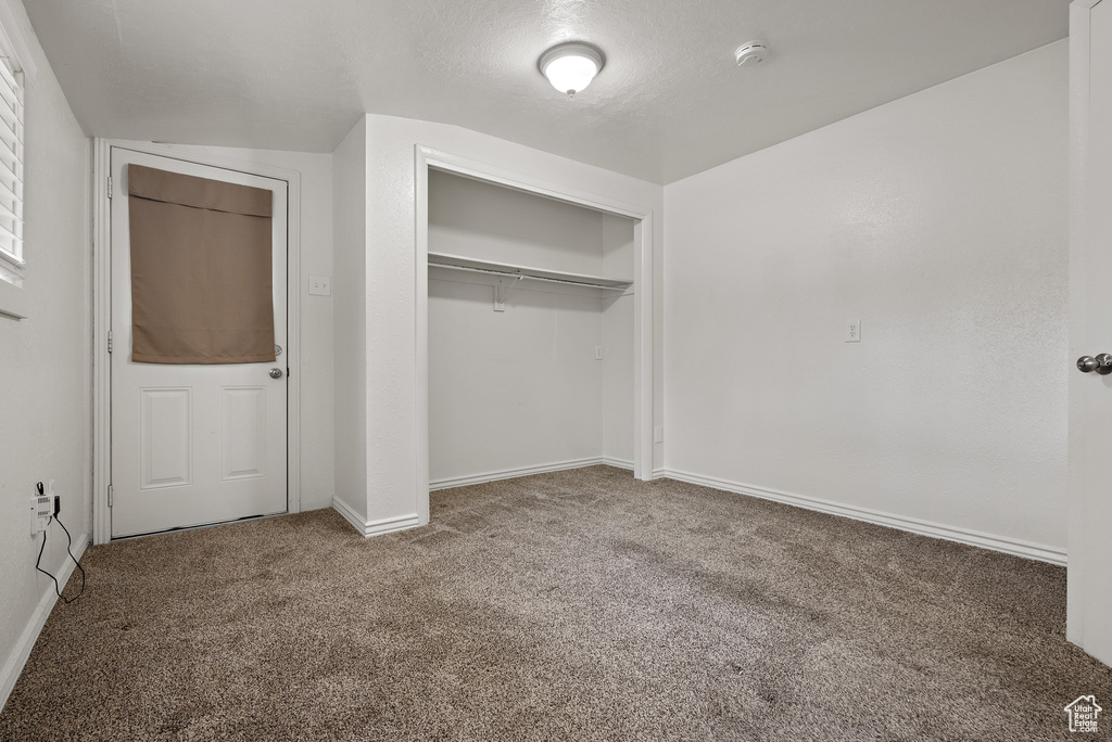 Unfurnished bedroom featuring carpet flooring and a closet