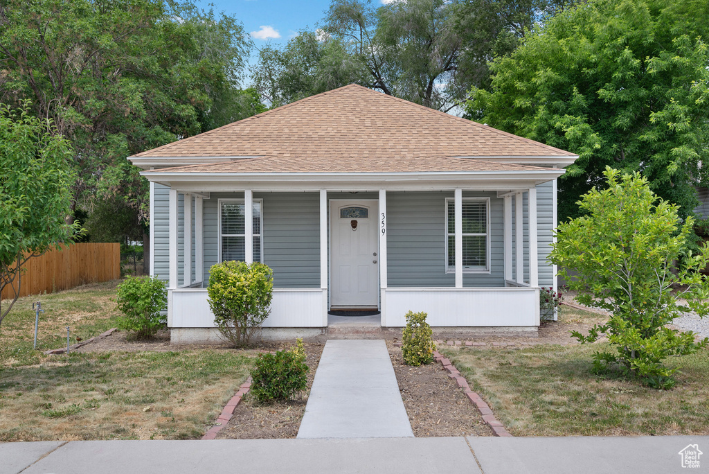 Bungalow-style home featuring roof with shingles and covered porch