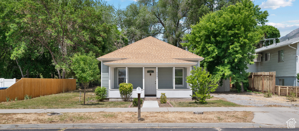 View of front of home with a porch and a shingled roof
