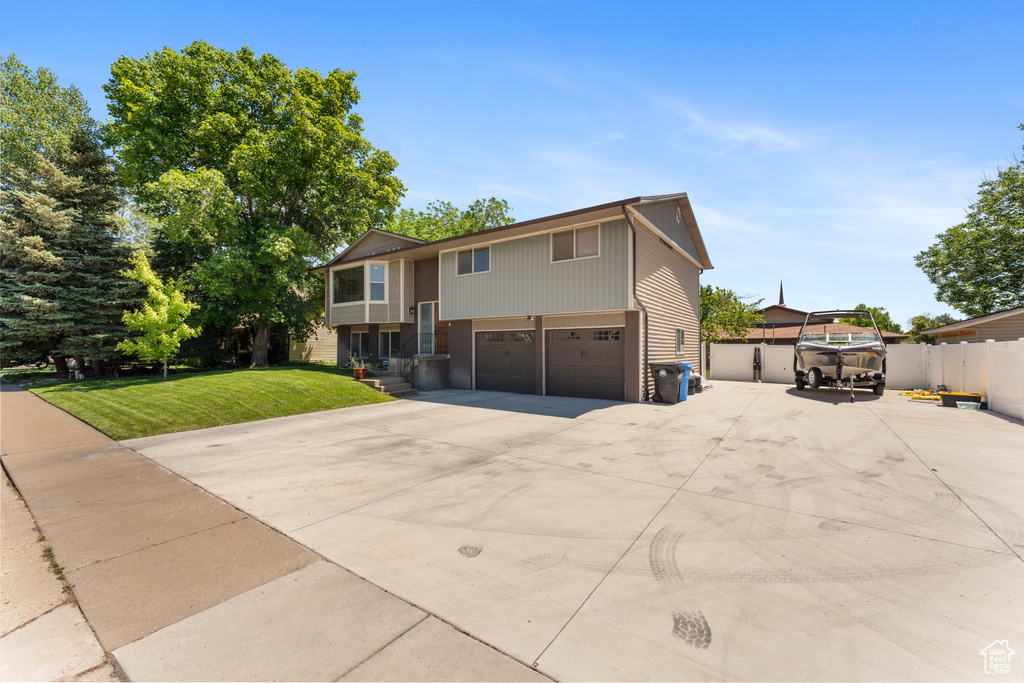 Raised ranch featuring a garage and driveway