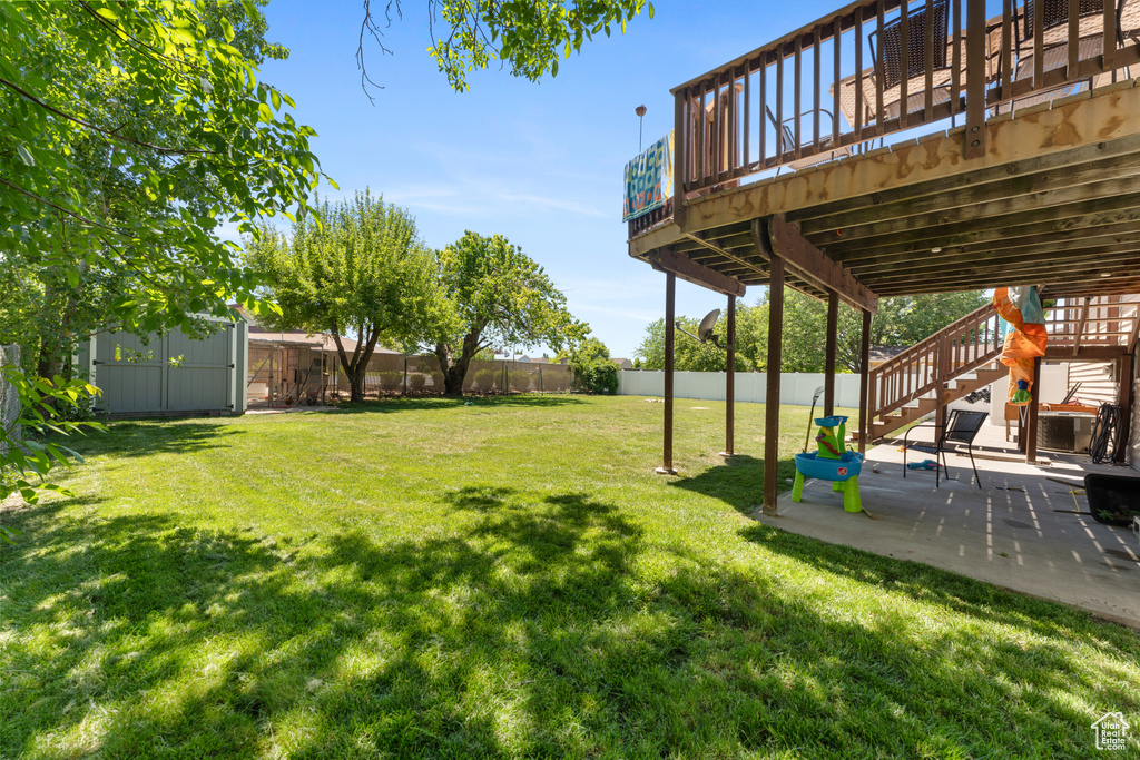 View of yard featuring stairway, a patio, and a wooden deck