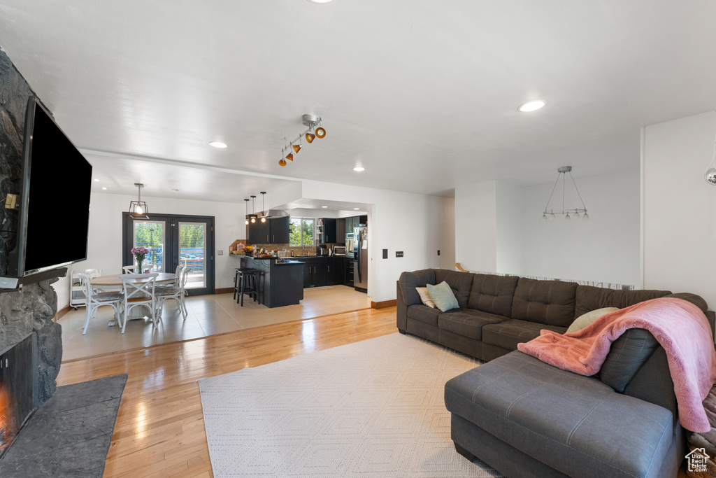Living area with light wood-style floors, recessed lighting, and a fireplace