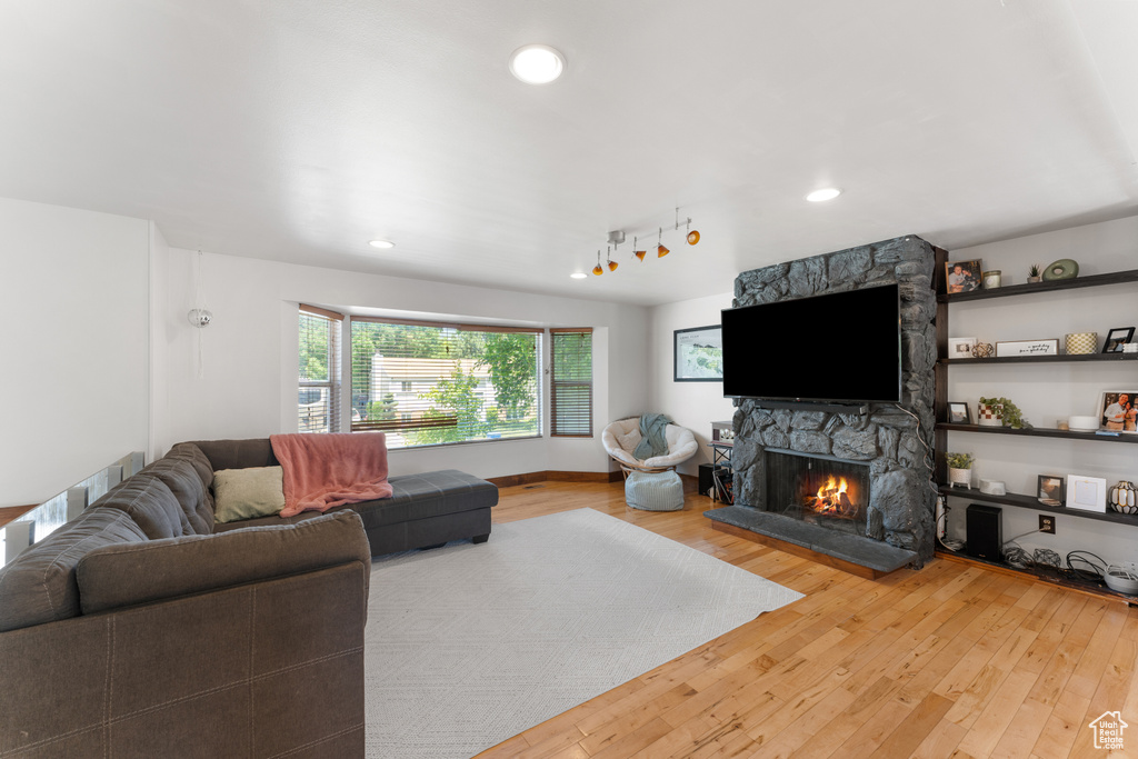 Living area featuring hardwood / wood-style floors, a stone fireplace, and recessed lighting