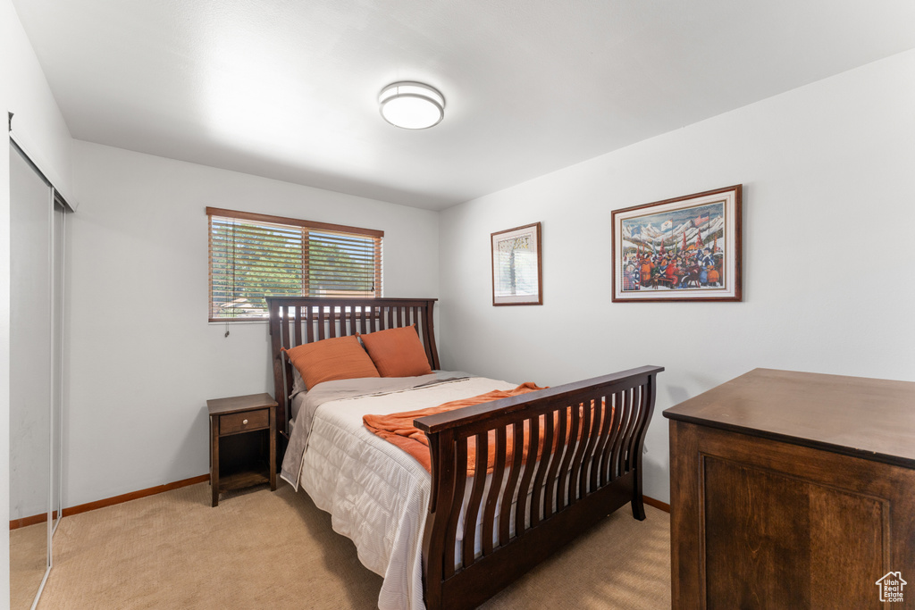 Bedroom featuring light colored carpet and baseboards
