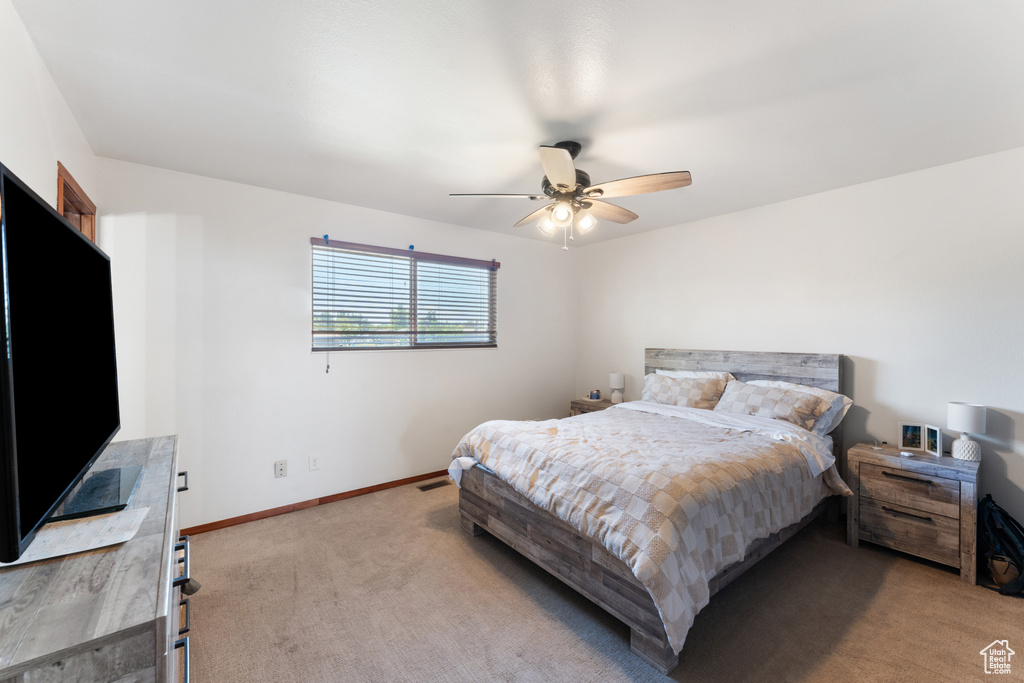 Carpeted bedroom with baseboards and ceiling fan