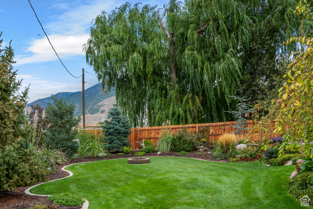 View of yard with a mountain view and an outdoor fire pit