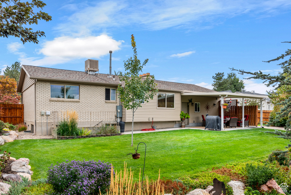 Rear view of property featuring a patio area, a chimney, and brick siding