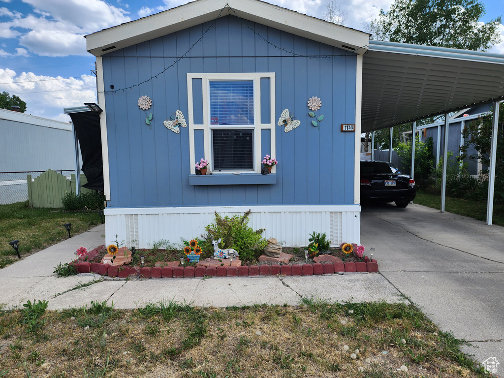 View of front facade with concrete driveway and an attached carport