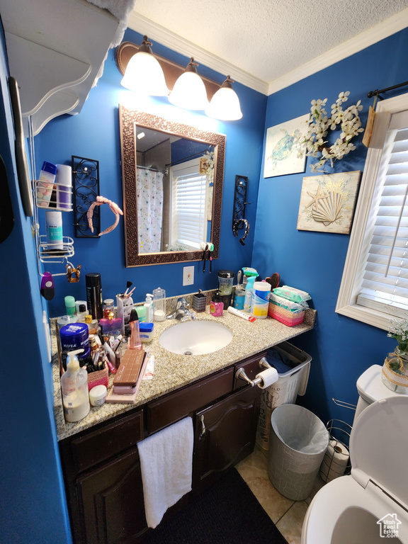 Full bathroom featuring vanity, a textured ceiling, tile patterned flooring, and crown molding