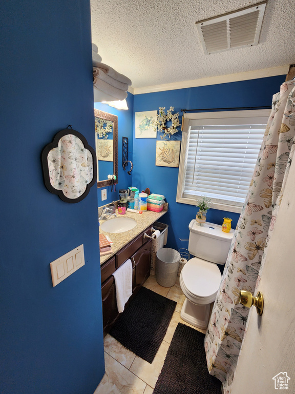 Bathroom with vanity, a textured ceiling, and tile patterned floors