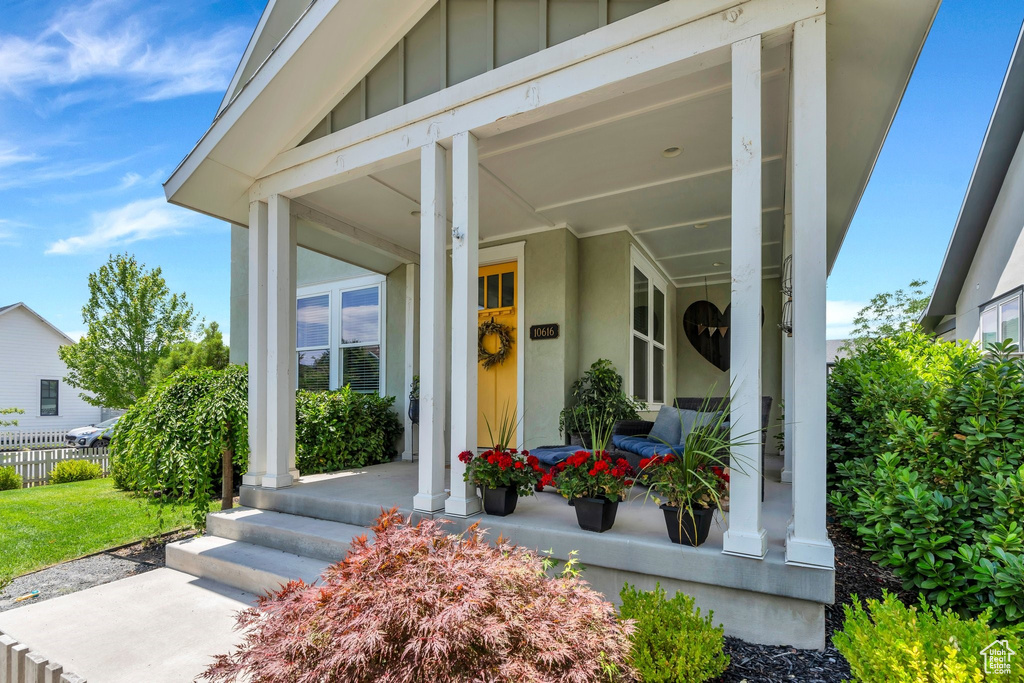 View of exterior entry featuring covered porch and board and batten siding