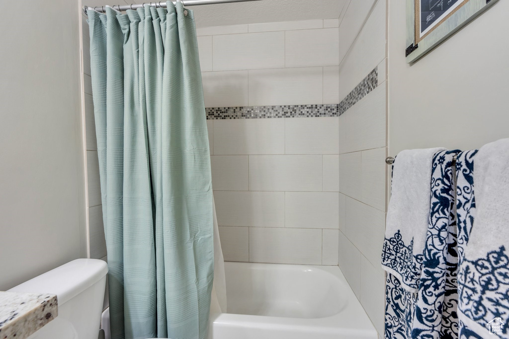 Bathroom featuring shower / tub combo and toilet