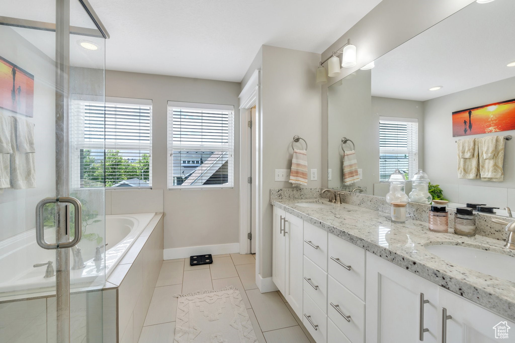 Full bathroom featuring double vanity, a bath, tile patterned floors, a shower stall, and recessed lighting