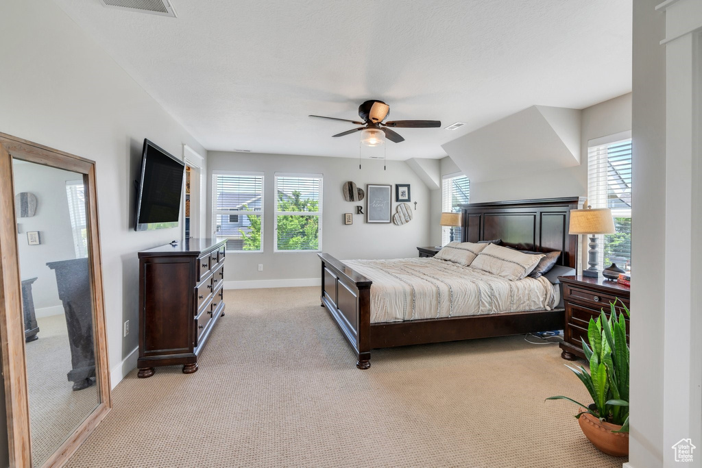 Bedroom with light carpet and a ceiling fan