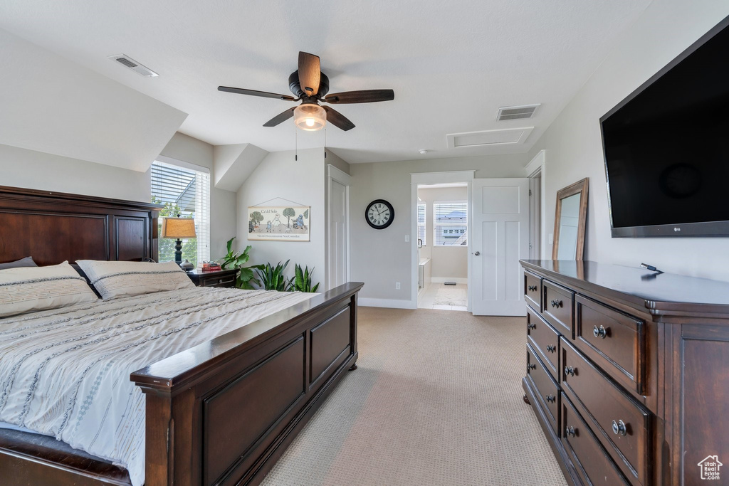 Bedroom with attic access, light carpet, and a ceiling fan