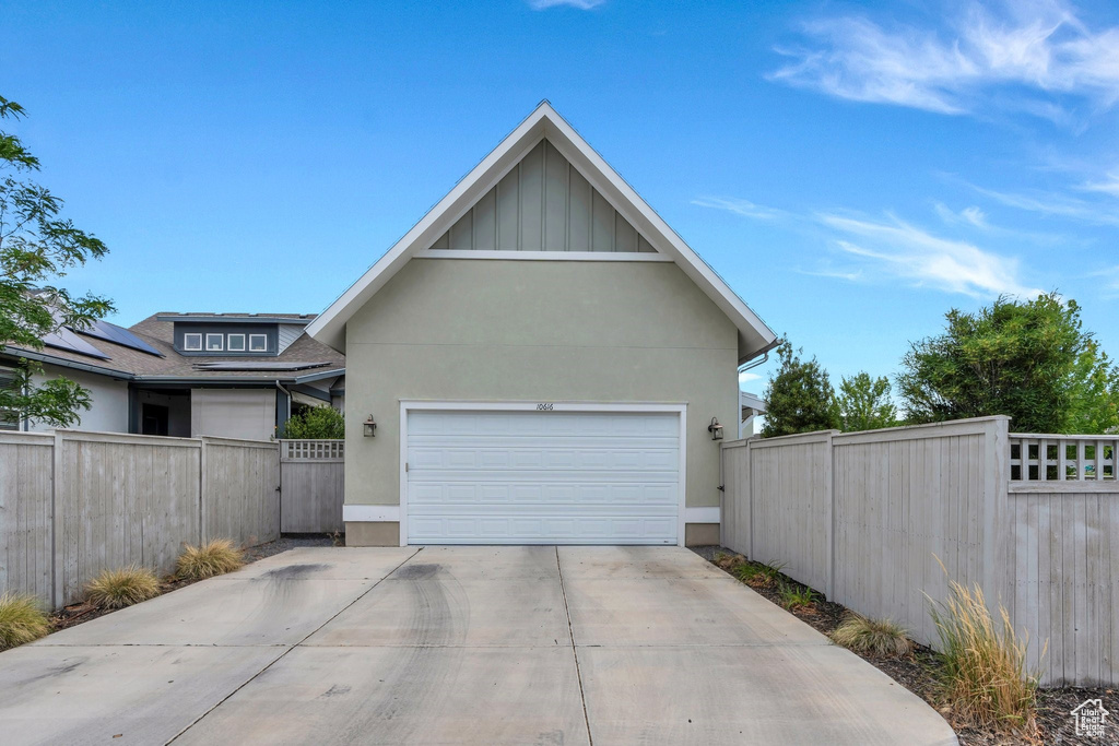 View of front of house featuring stucco siding, concrete driveway, board and batten siding, and a garage