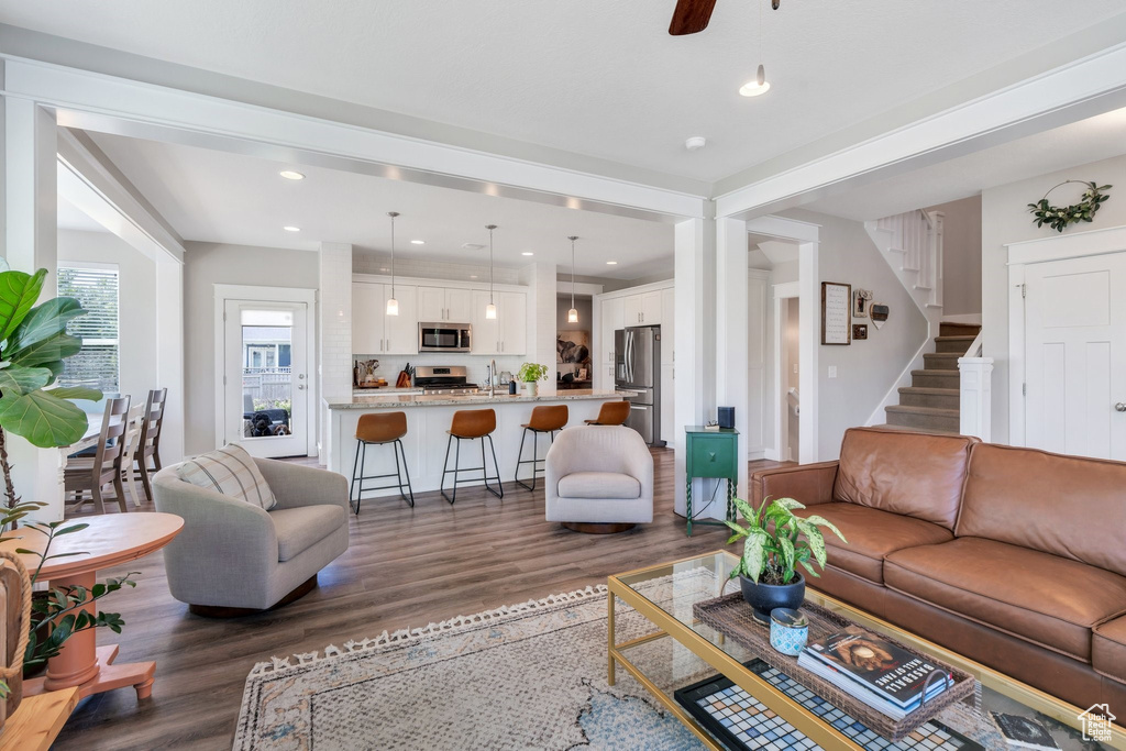 Living area with wood finished floors, recessed lighting, stairs, and ceiling fan