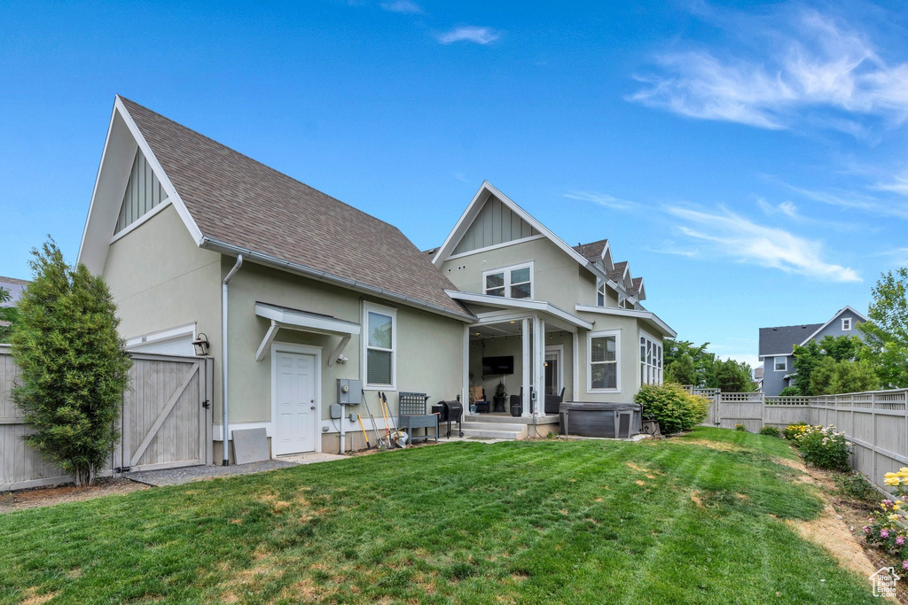 Back of property with a gate, a fenced backyard, roof with shingles, and stucco siding