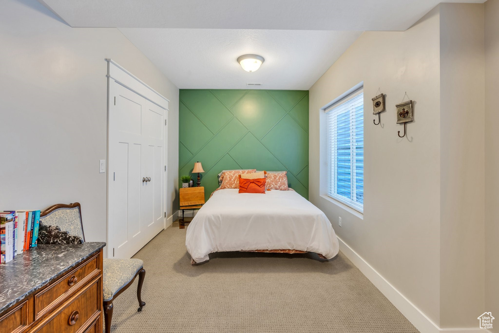 Bedroom featuring light colored carpet and baseboards