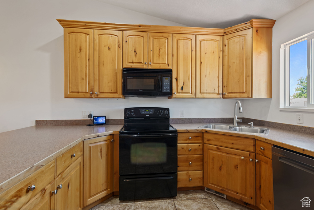 Kitchen featuring black microwave, electric range, dishwashing machine, and lofted ceiling