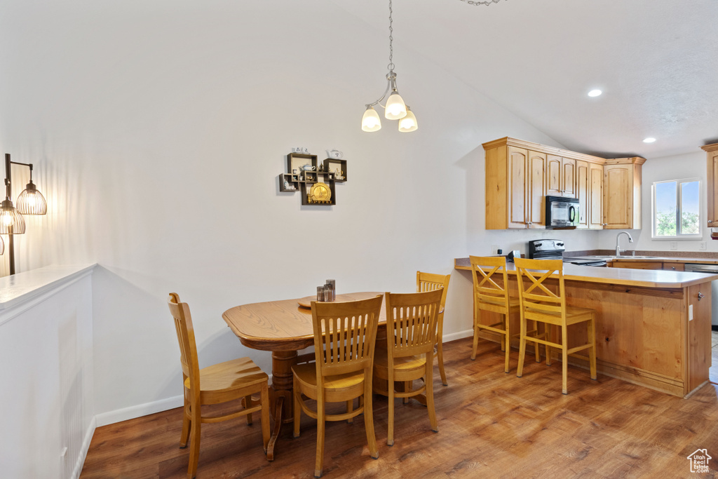 Dining room featuring vaulted ceiling, light wood finished floors, and recessed lighting