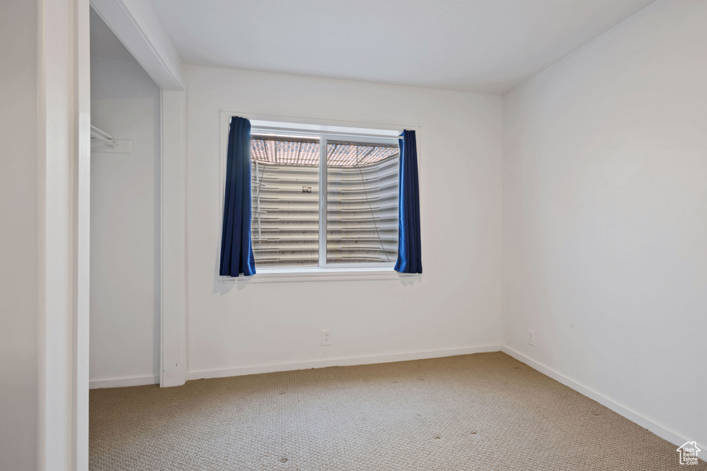 Carpeted empty room with baseboards
