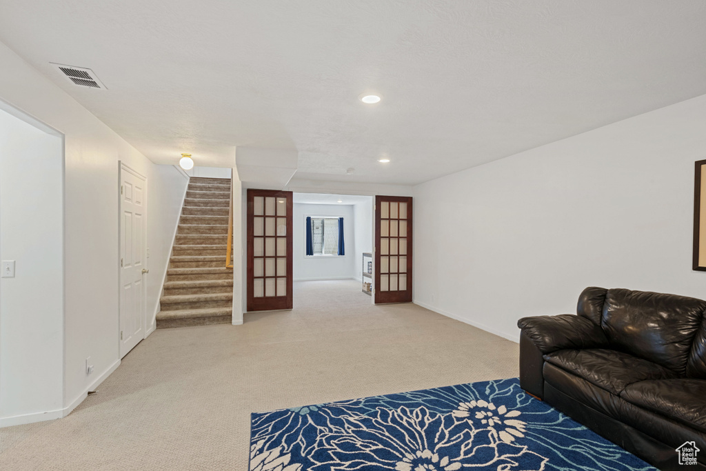 Living room featuring carpet flooring, stairs, and recessed lighting