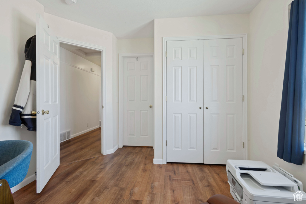 Bedroom with a closet and dark wood-style flooring
