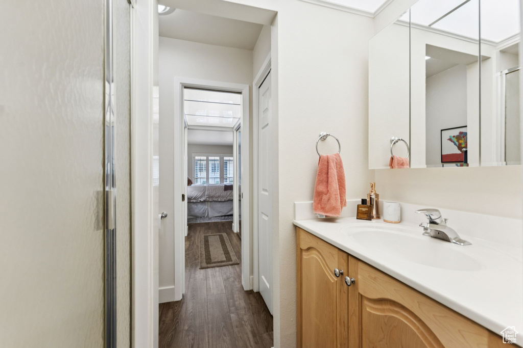 Ensuite bathroom featuring vanity, wood finished floors, and a shower stall
