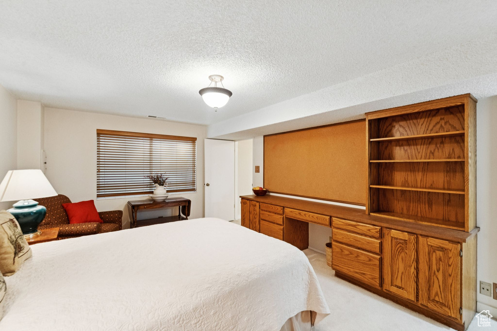 Bedroom with light carpet and a textured ceiling