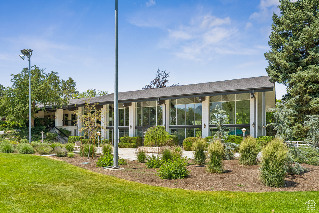 Rear view of house featuring a lawn and a sunroom