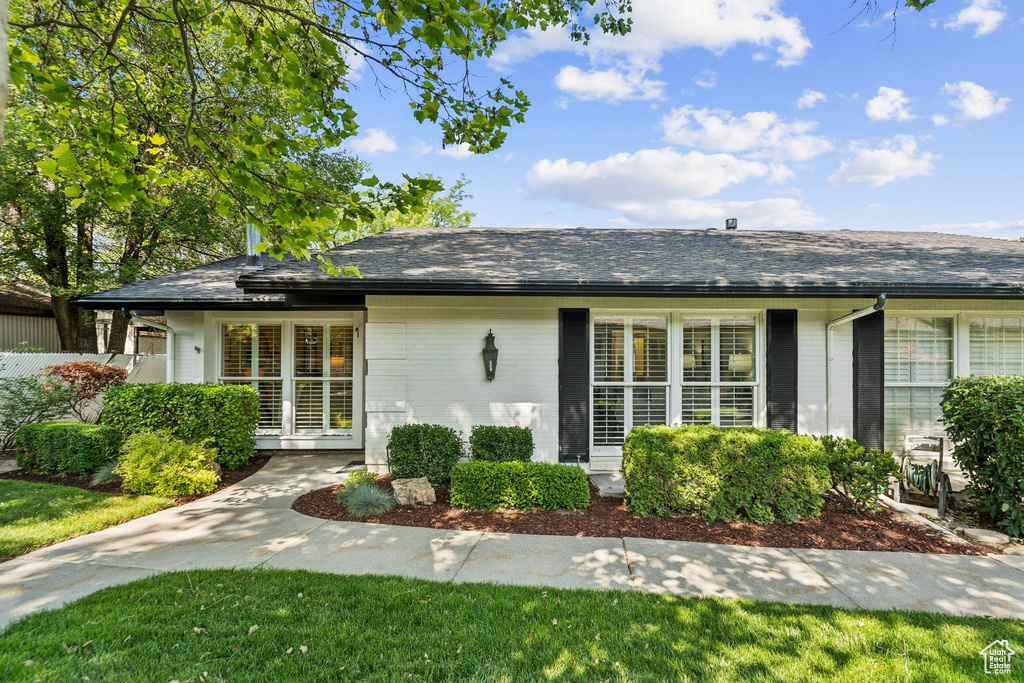 Single story home featuring brick siding and a shingled roof