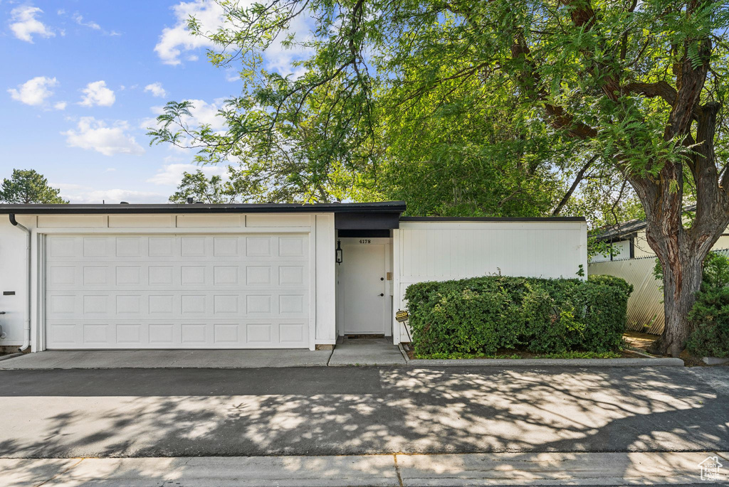 Mid-century modern home featuring a garage and driveway