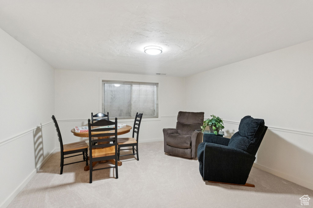 Dining room with light colored carpet and baseboards