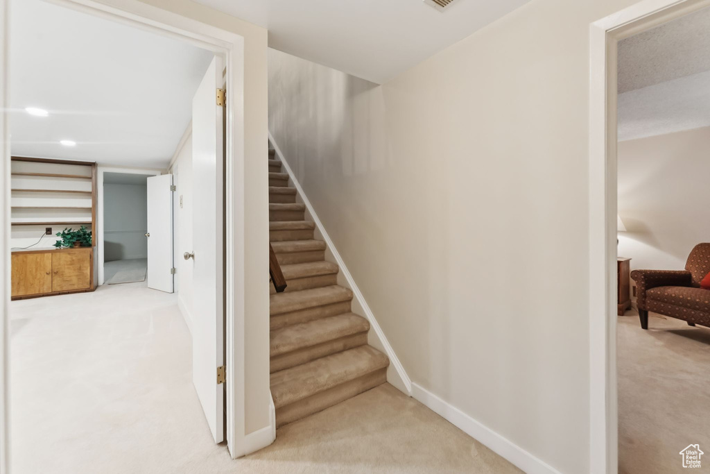 Staircase featuring carpet floors and baseboards