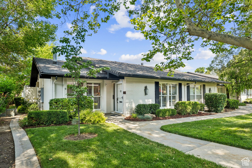 Ranch-style home featuring a front yard and brick siding