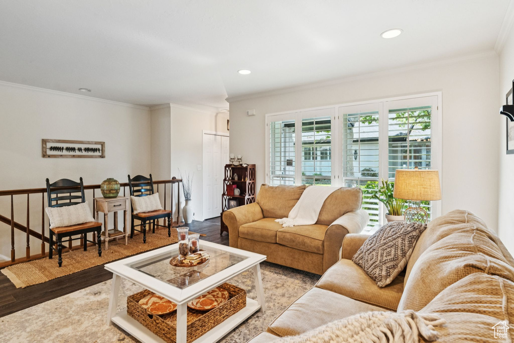 Living area featuring wood finished floors, ornamental molding, and recessed lighting