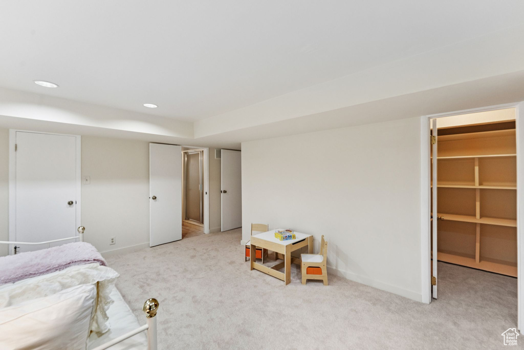 Bedroom with light colored carpet, baseboards, recessed lighting, and a spacious closet